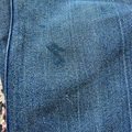 Close-up of blue denim fabric with a visible stain.
