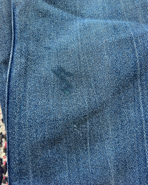Close-up of blue denim fabric with a visible stain.