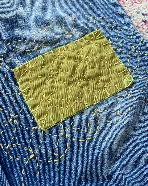 Green embroidered patch on blue fabric