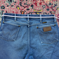 Blue jeans with a measuring tape on a patterned rug