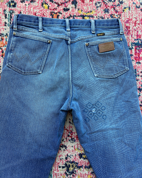 Blue jeans with a brand label on a patterned rug
