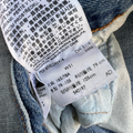 Close-up of a label on a piece of denim fabric with text and numbers.