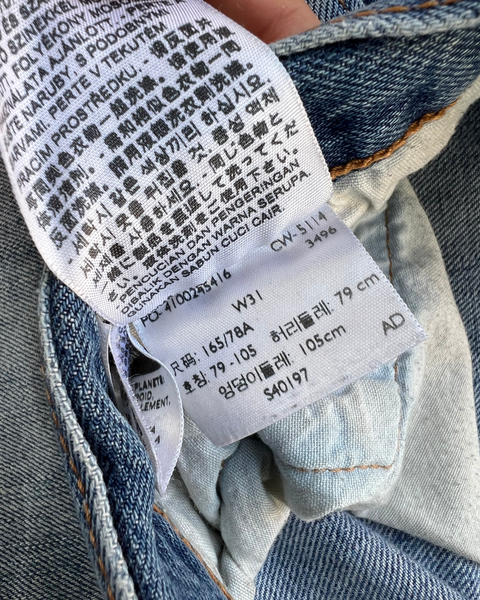 Close-up of a label on a piece of denim fabric with text and numbers.