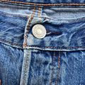 Close-up of a blue denim button on a jacket