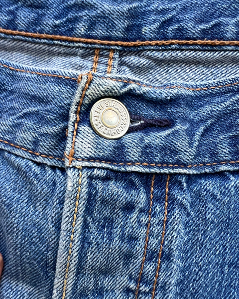 Close-up of a blue denim button on a jacket