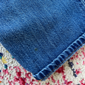 Close-up of blue denim fabric on a multicolored textured surface
