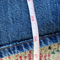 Close-up of blue jeans with a measuring tape indicating size 36
