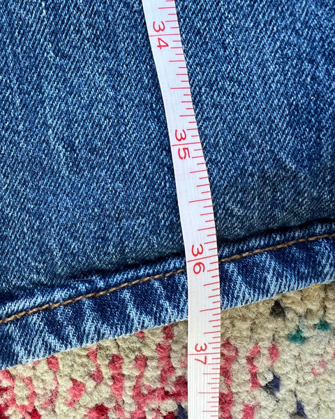 Close-up of blue jeans with a measuring tape indicating size 36