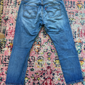Blue jeans on a multicolored patterned rug