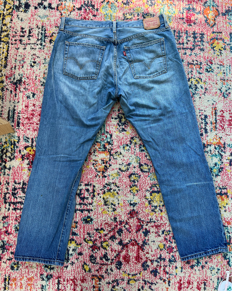 Blue jeans on a multicolored patterned rug