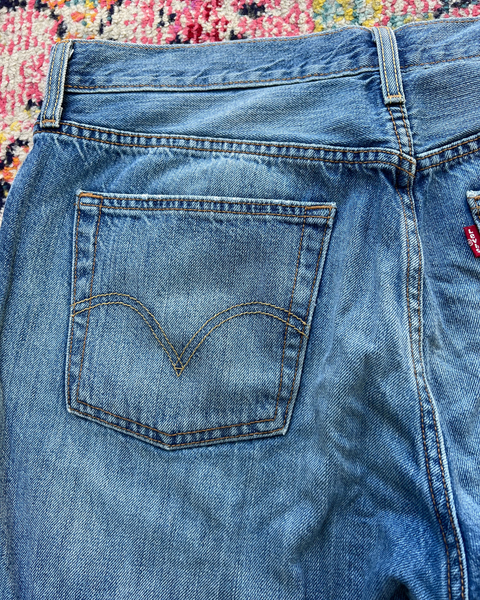 Close-up of blue Levi's jeans with a floral pattern in the background
