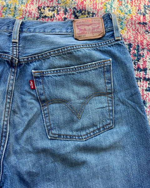Close-up of blue Levi's jeans with brand logo on a colorful patterned background