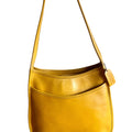 Yellow leather handbag with a strap on a white background