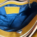 Close-up of a yellow and blue bag with a visible brand label.